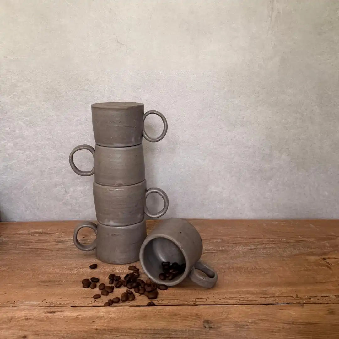 Fünf AREIA Natural EspressoBecher gestapelt und gruppiert auf Holztisch