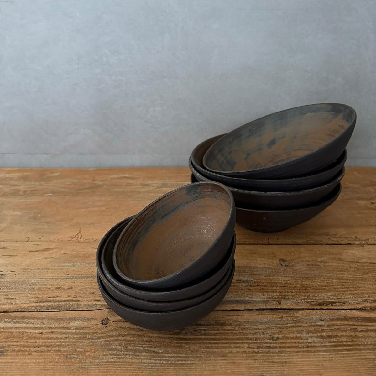 Stapel aus jeweils 4 AREIA Negra Müsli - und Suppenschüsseln, handgedrehtes Steinzeug, natürliche Nuancen und Drehspuren sichtbar