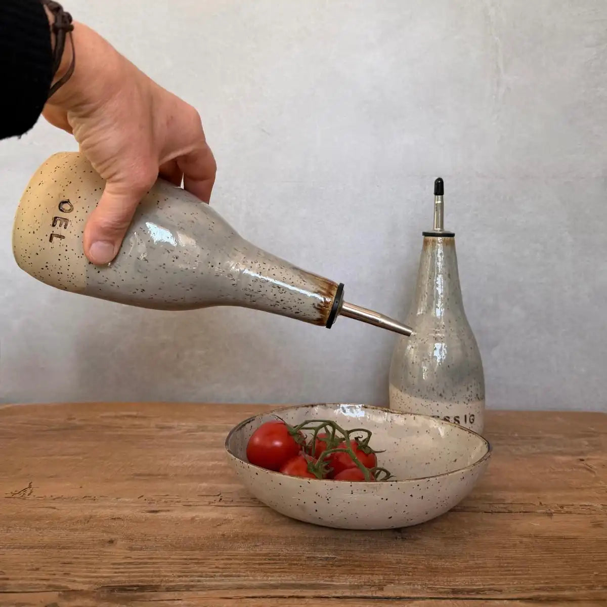 BOHEMIAN Grey Keramik Öl- & Essigspender in Verwendung mit frischen Tomaten auf einem Holztablett.