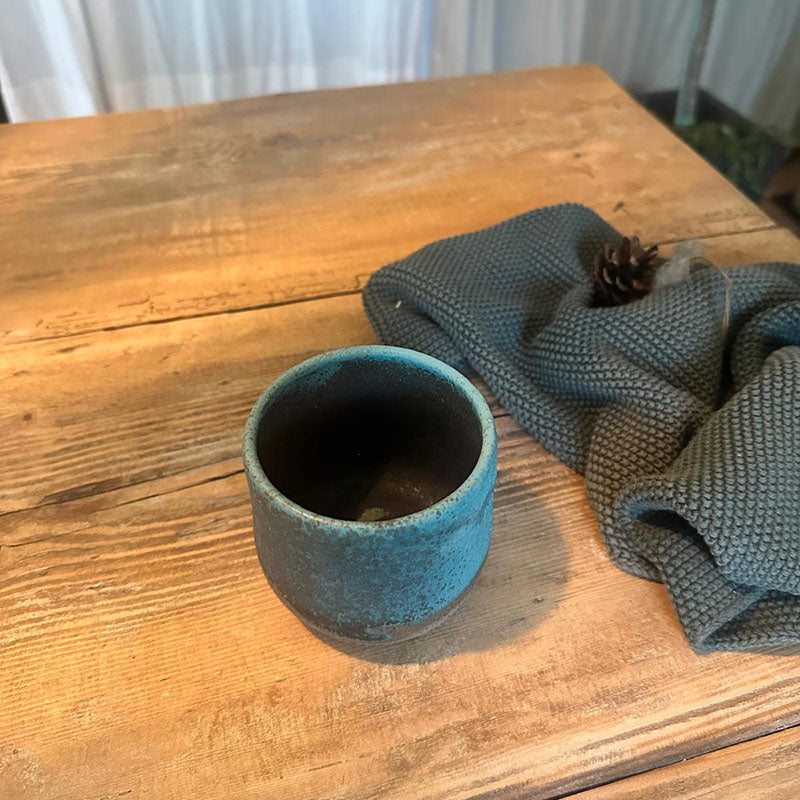 Keramikbecher aus grauem Ton mit türkiser, matter Glasur