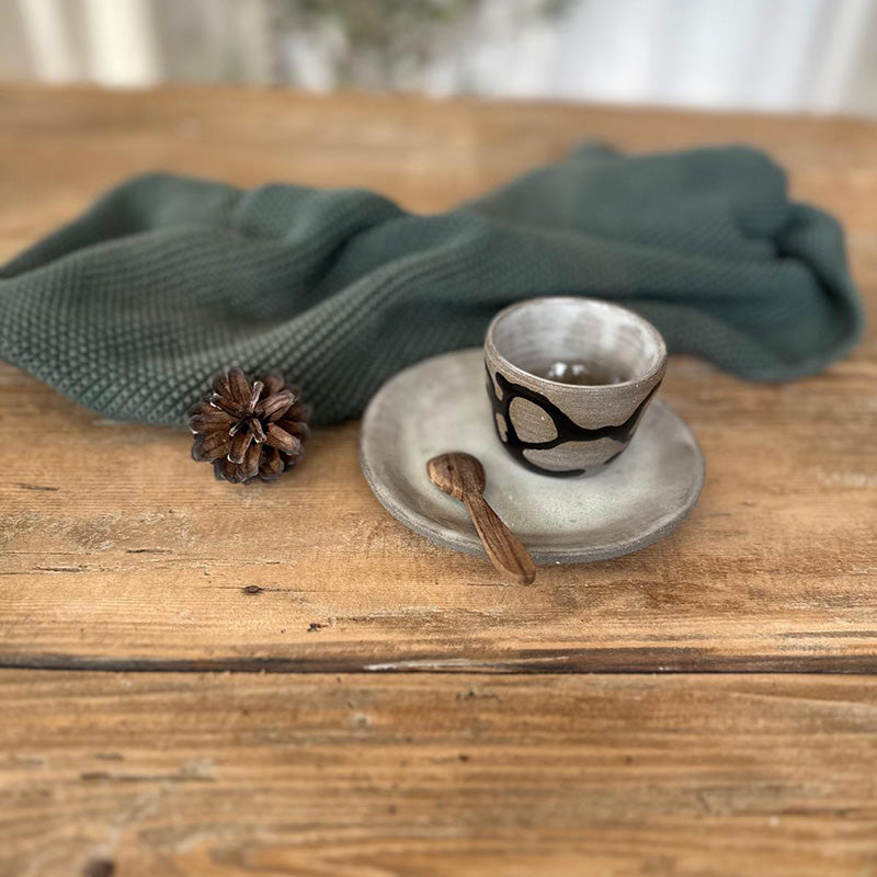 Nahaufnahme Espressoset, mit weiß glasiertem Teller, und Becher mit Schlangenlinie