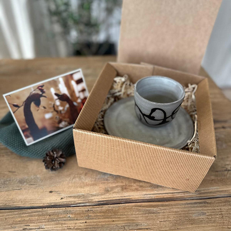 Geschenkset mit Keramikbecher und Teller, Naturverpackung mit Tannenzweig und Karte zu Weihnachten