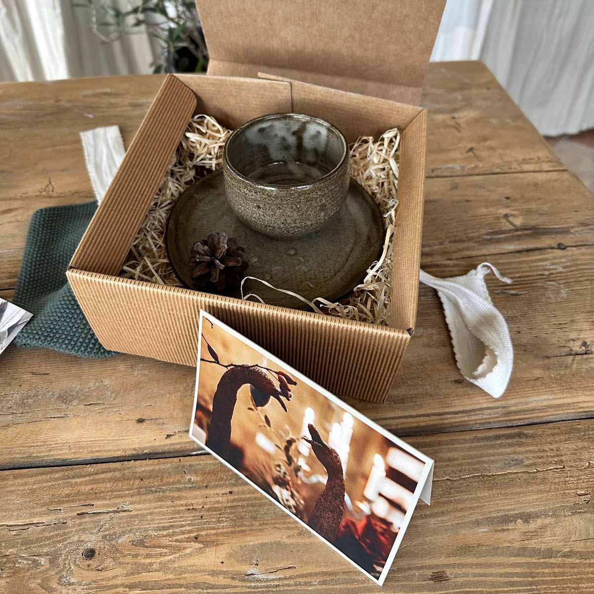 Geschenkset mit dickwandigem Keramikbecher und Teller, nachhaltig in Naturverpackung arrangiert