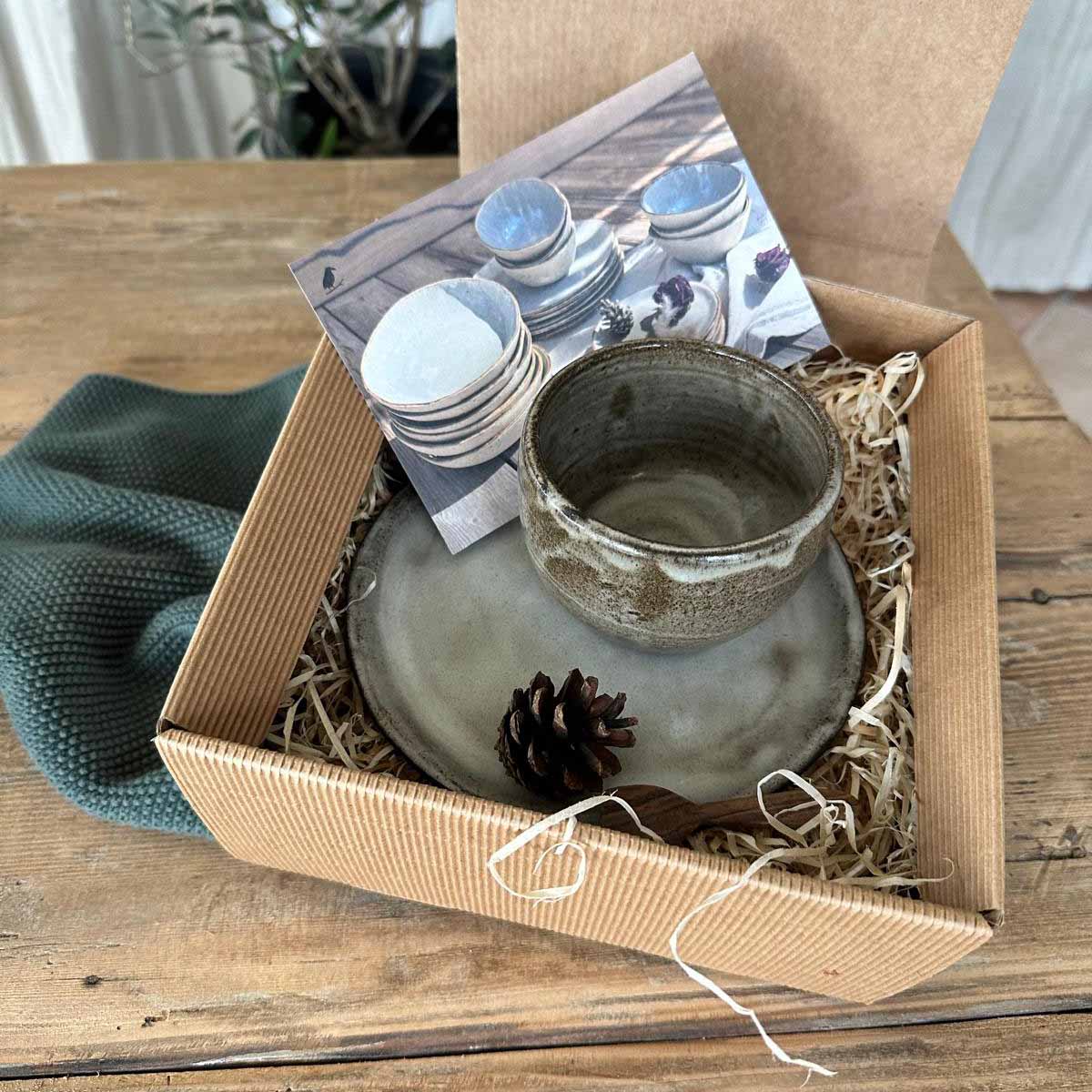 Geschenkset mit dickwandigem Keramikbecher und weißem Teller, nachhaltig verpackt im Naturkarton