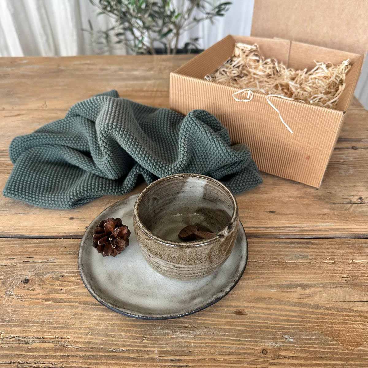 Dickwandiger Keramikbecher in braun-weißer Glasur auf weiß glasiertem Teller, handgemacht von FRANZART