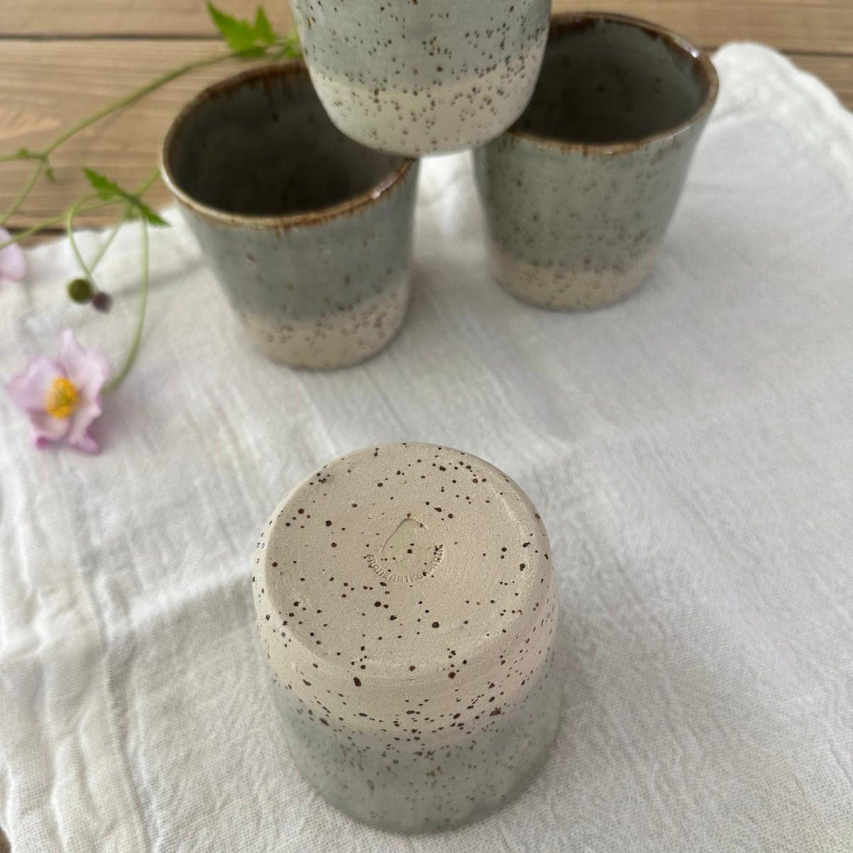 Becherunterseite eines von 4 getöpferter Keramikbechern in grau beige