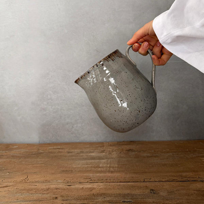 Keramikkrug BOHEMIAN Grey beim Ausschenken, Grau mit braunem Rand