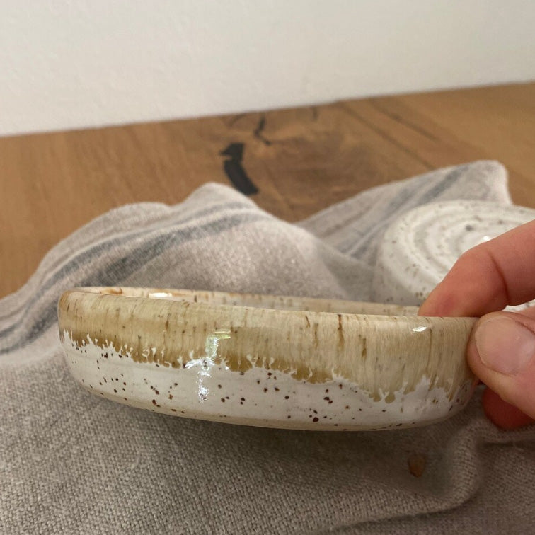 Runde Keramikseifenschale mit Löchern für das Tropfwasser und einer Auffangschale, weißer Steinzeugton mit Spots.
