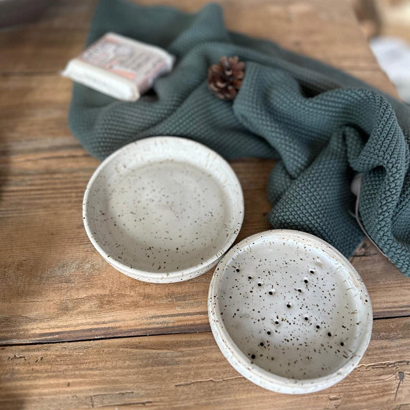 Weiße Keramik-Seifenschale mit passender Unterschale auf rustikalem Holztisch