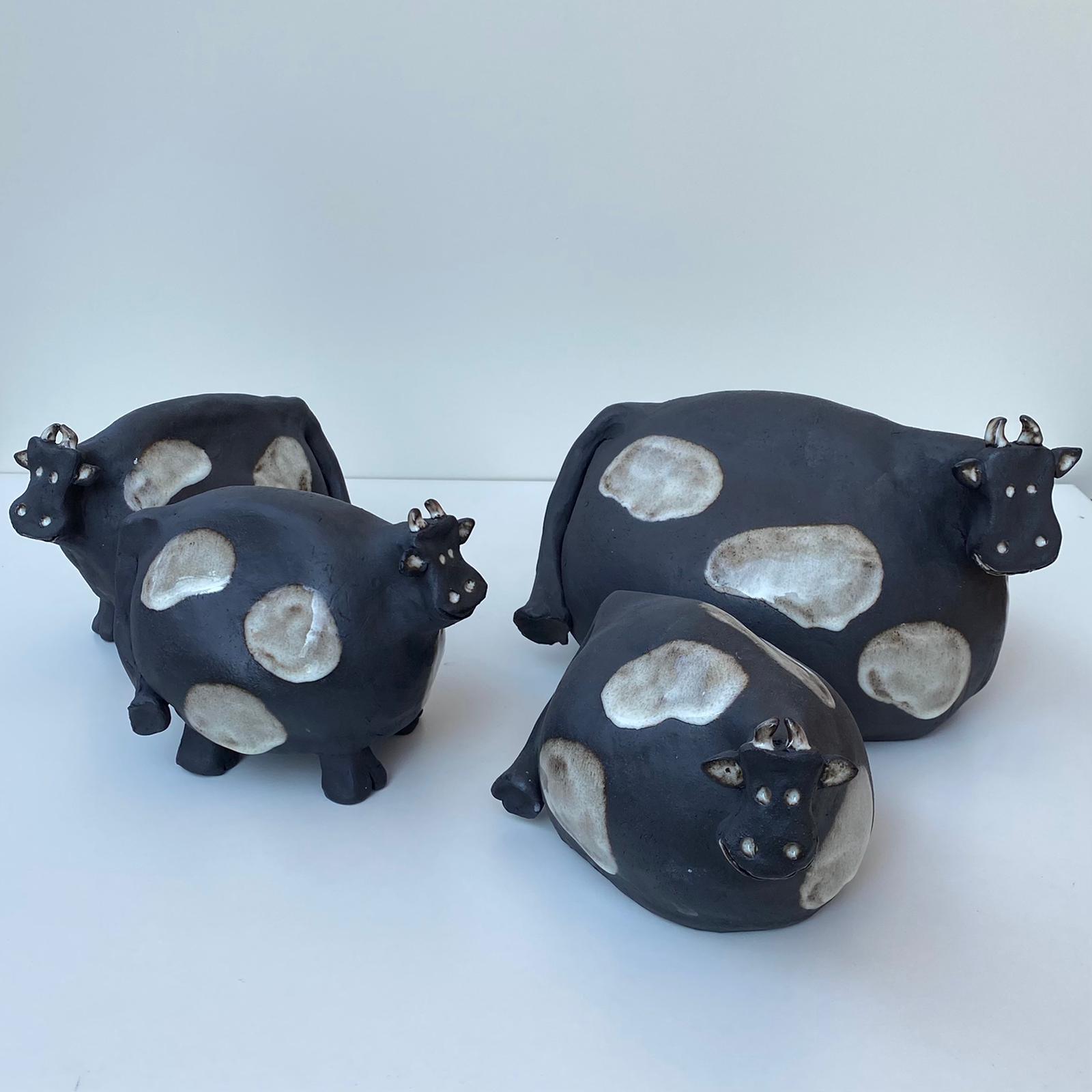 Schwarz-weiß gefleckte Kühe aus Keramik, schwarzer Steinzeugton.