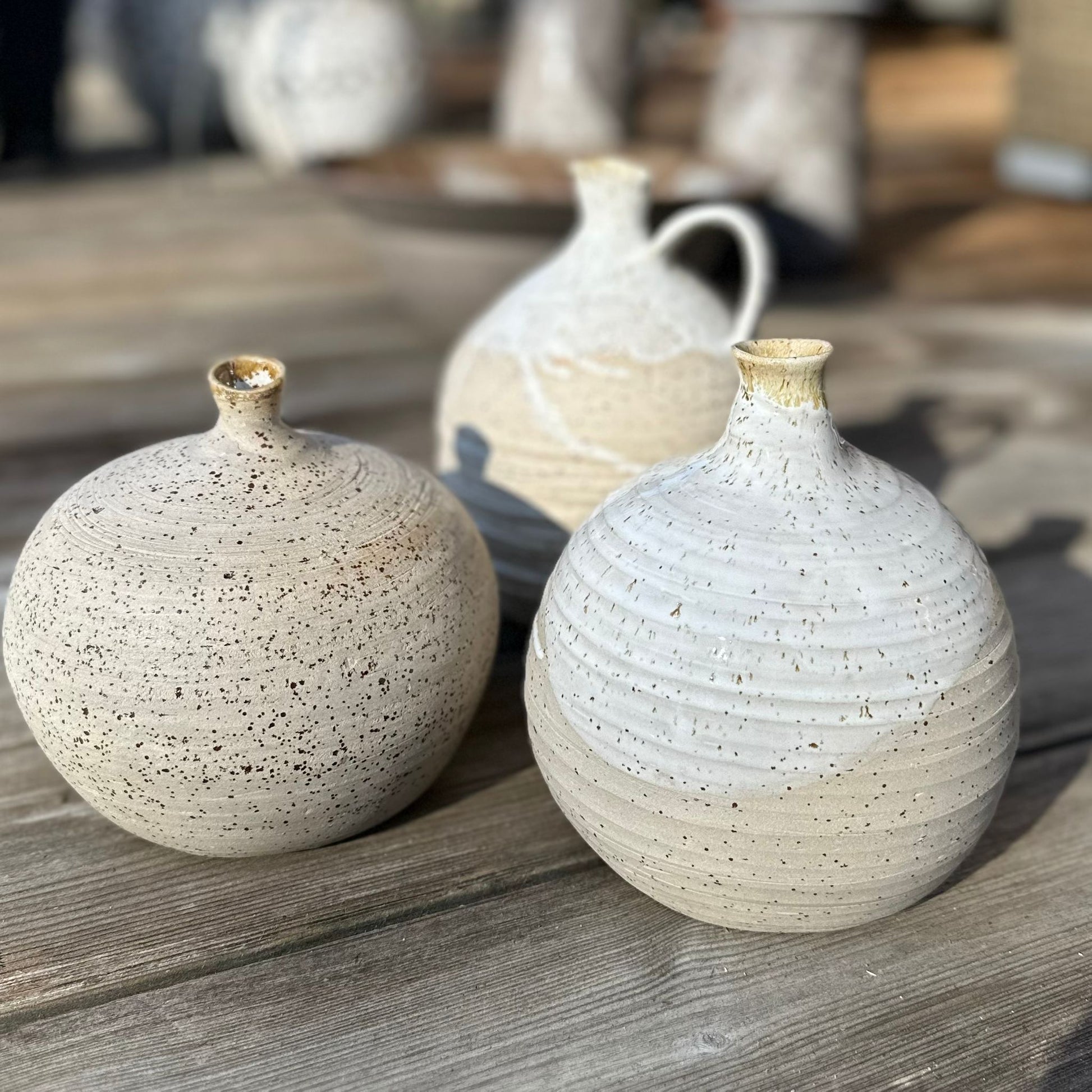 Drei Kugelvasen, Luftballonvasen, beiger Steinzeugton mit teilweise weißer Glasur, eine Vase mit Henkel