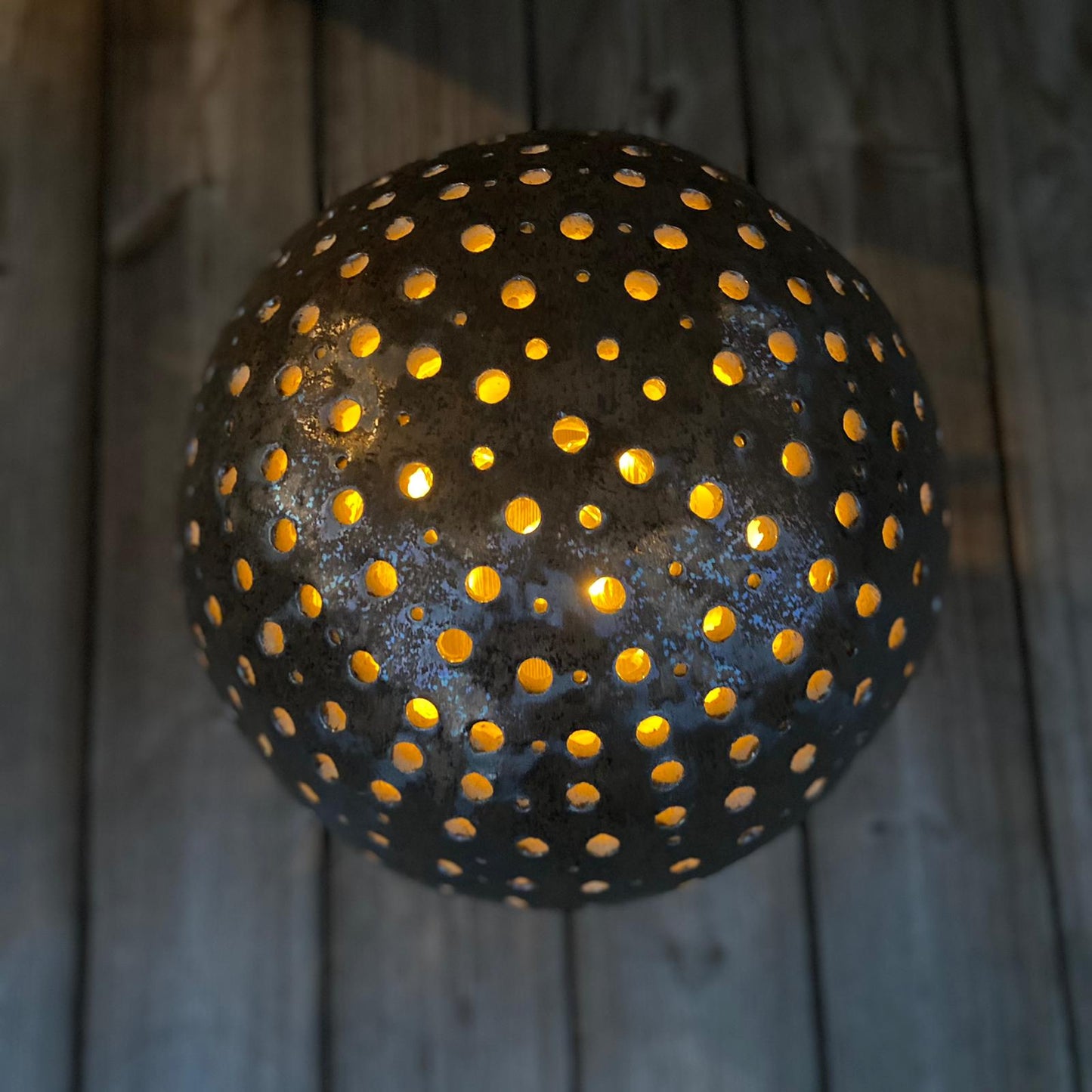 Lichterkugel aus Keramik, Bronzeglasur, Ø ca 40 cm, mit einer Kerze beleuchtet, Ansicht von oben.