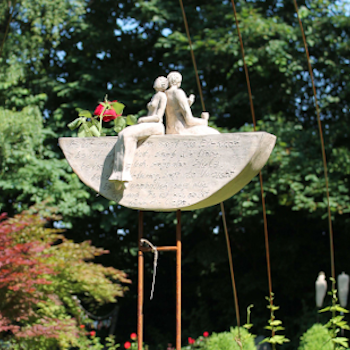 Vase oder Kerzenschiff für Garten, Terrasse oder Balkon. Mit Spruch auf der Vorderseite. Oben sitzen, Rücken an Rücken, eine Frau und ein Mann.