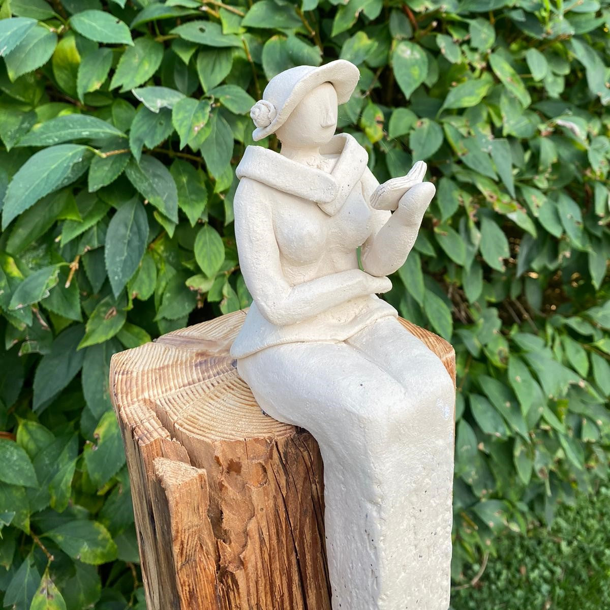 Sitzende Keramikdame aus weißem Steinzeugton liest ein Buch und sitzt auf einem Ständer aus Antikholz