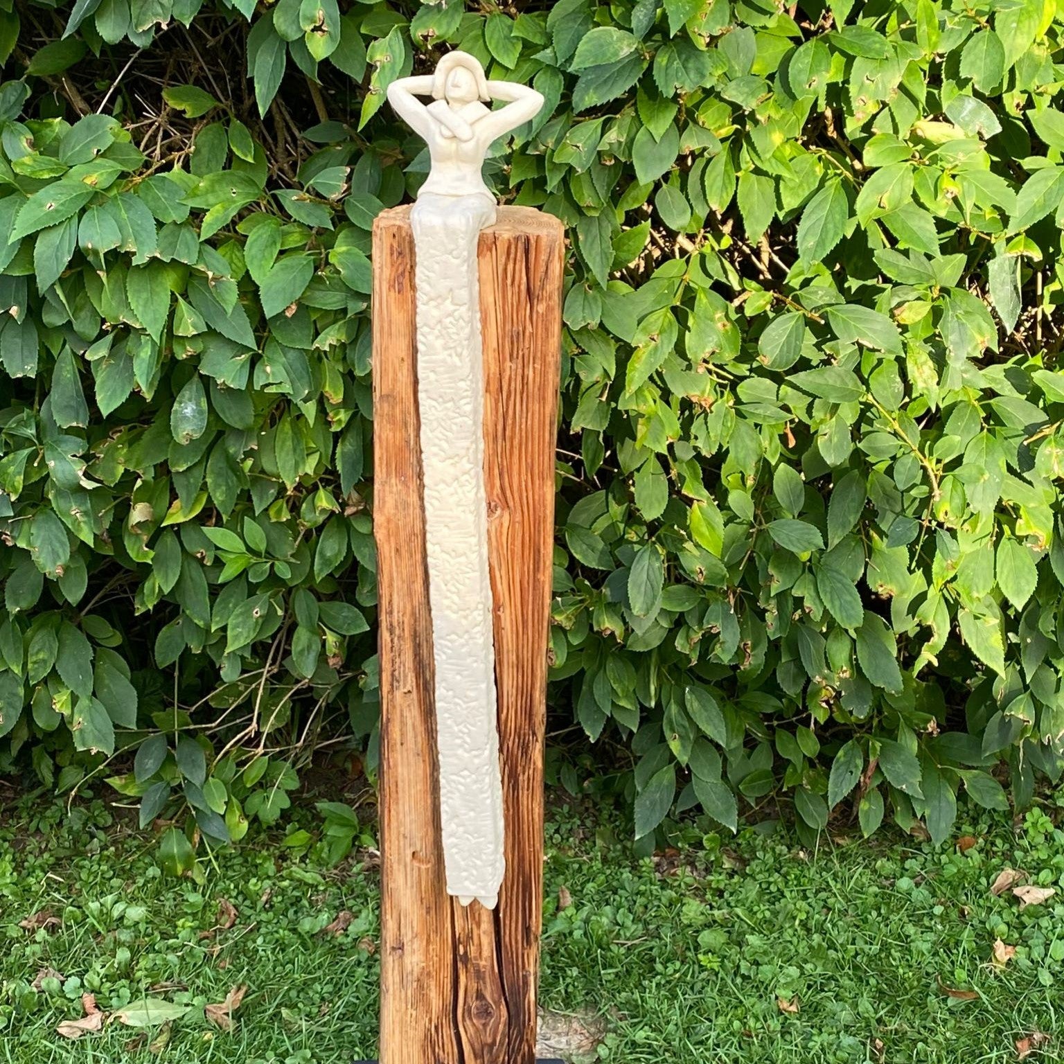 Keramikdame aus weißem Steinzeugton sitzt auf einem Ständer aus Altholz