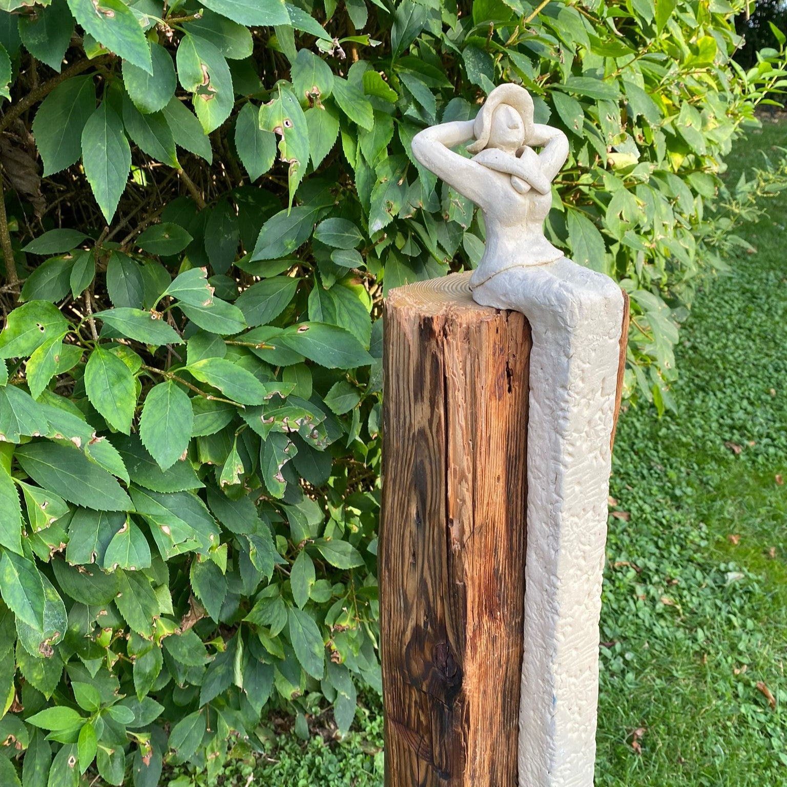Keramikdame aus weißem Steinzeugton sitzt auf einem Ständer aus Altholz