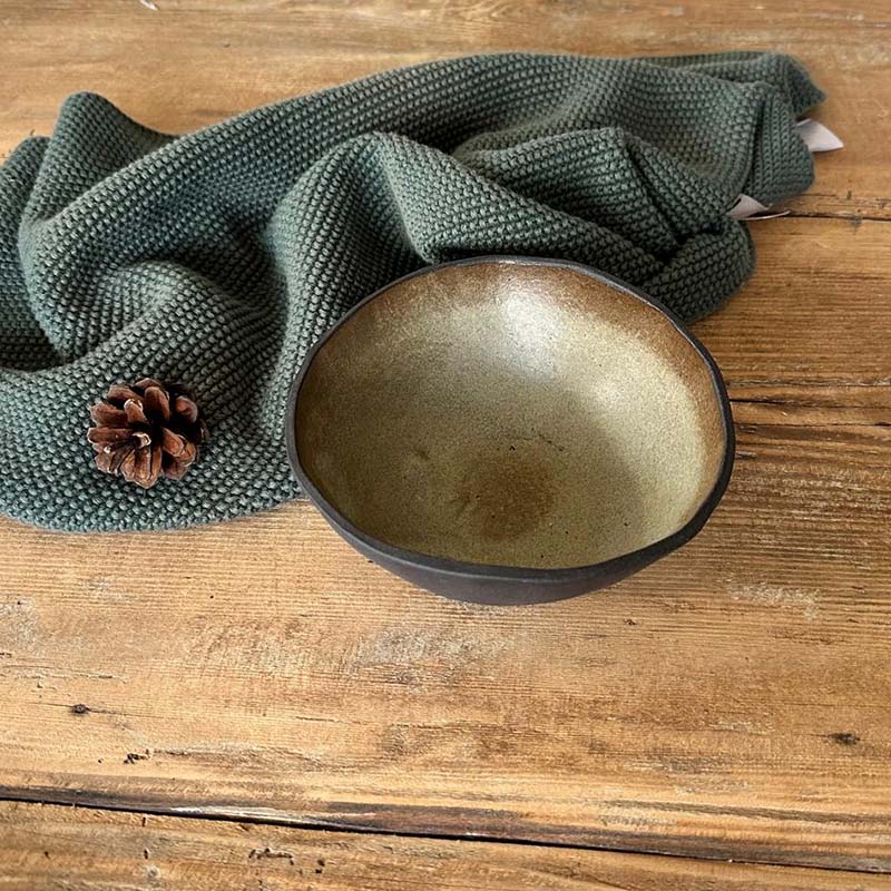 Draufsicht: Handgemachte Müslischüssel aus schwarzem Steinzeug mit grün-beiger, matter Glasur, geeignet für Frühstück und Bowls