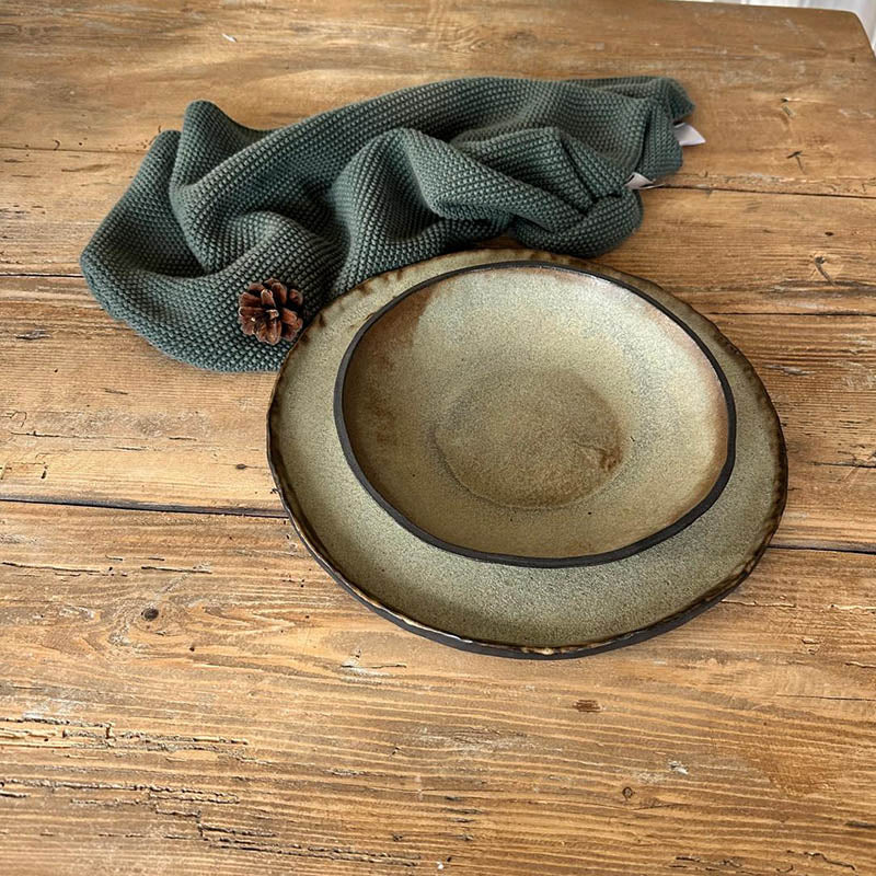 Einzeln arrangierte Teller und Schale  Holztisch, minimalistisches Tischgeschirr