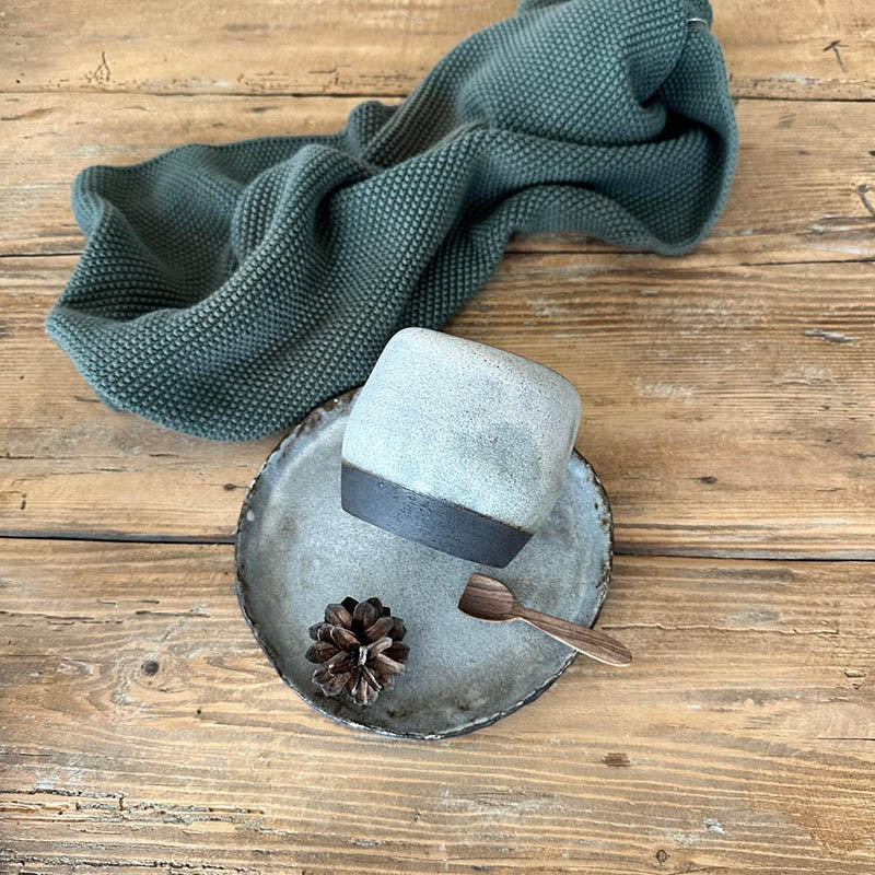 Detailansicht der matten Weißglasur, durch die der dunkle Ton dezent durchscheint