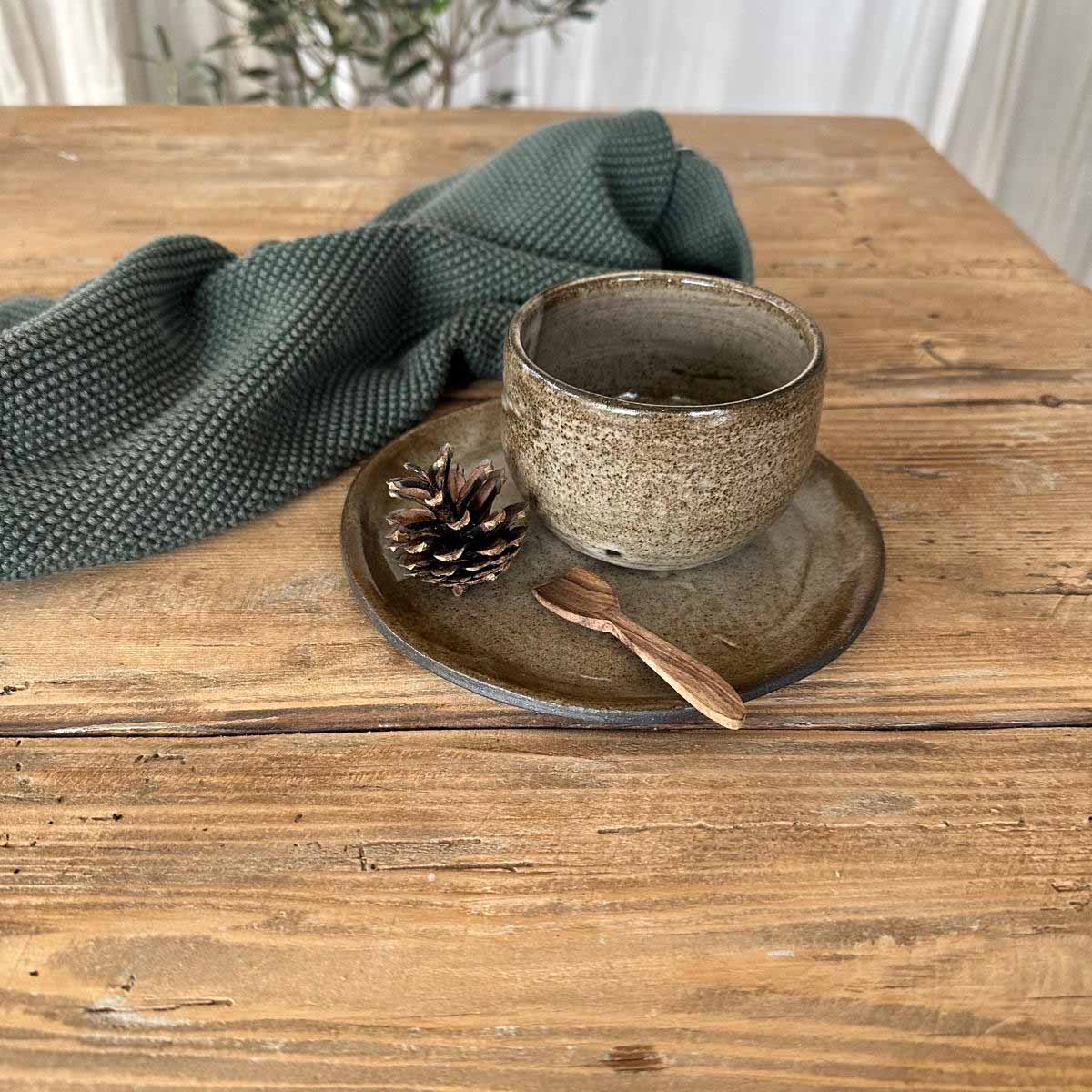 Becher und Teller aus Steinzeug mit braun-weißer Glasur, ideal für Winterkaffee oder Tee