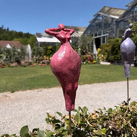 Keramikfigur in Rot auf Terrasse, abstrakte weibliche Silhouette mit erhobenen Armen
