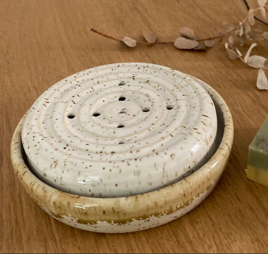 Runde Keramikseifenschale mit Löchern für das Tropfwasser und einer Auffangschale, weißer Steinzeugton mit Spots.