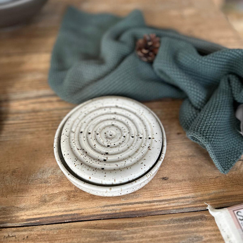 Weiße BOHEMIAN Seifenschale aus Steinzeug mit Spots vor grünem Handtuch