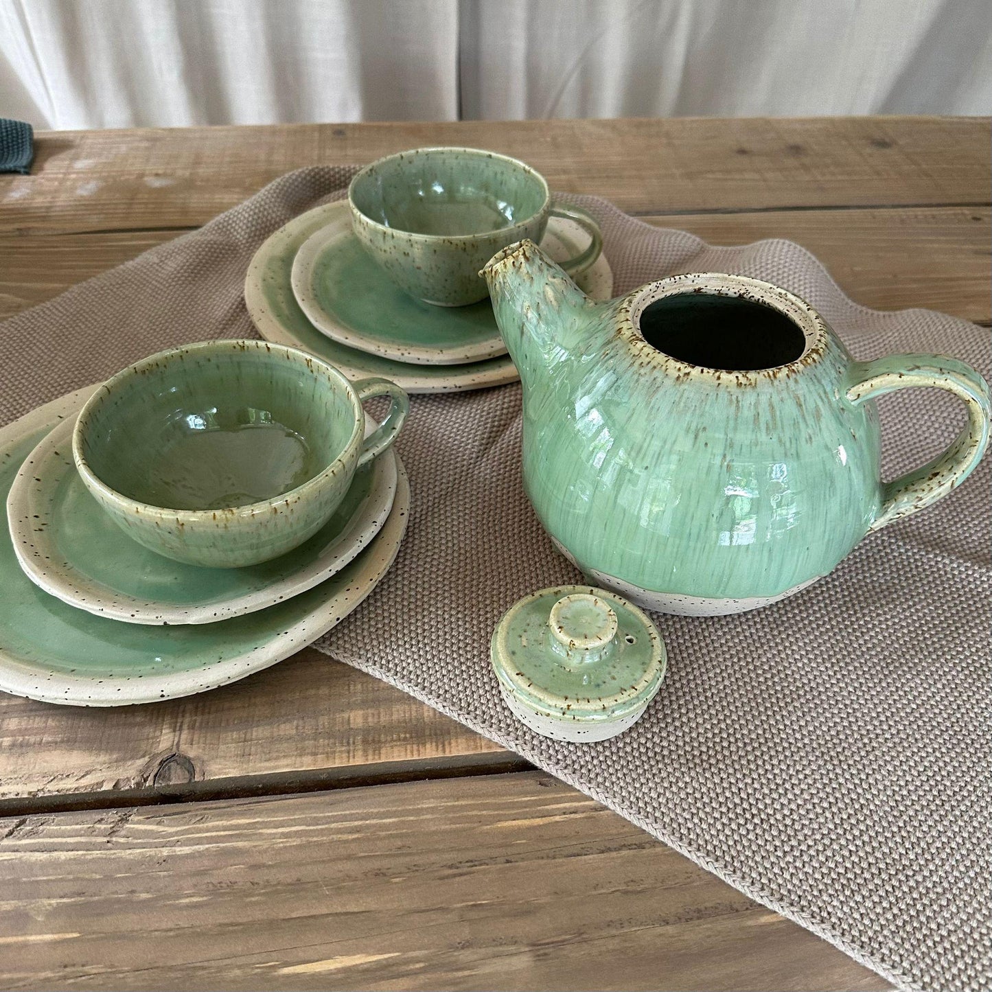 Tee Geschirr Set aus Steinzeugton mit Spots. Grüne, glänzende Glasur. Teekanne, 2  Teetassen mit Untertasse und 2 Desserteller.