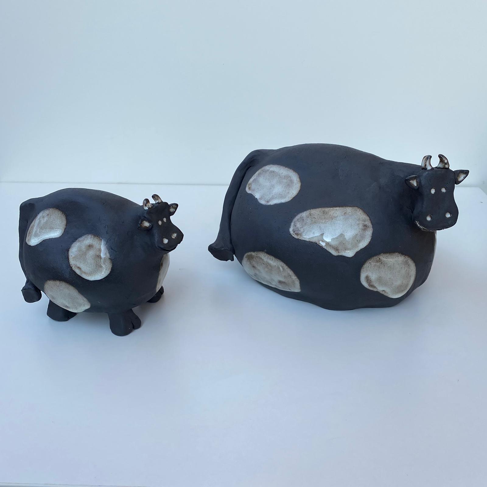 Schwarz-weiß gefleckte Kühe aus Keramik, schwarzer Steinzeugton.