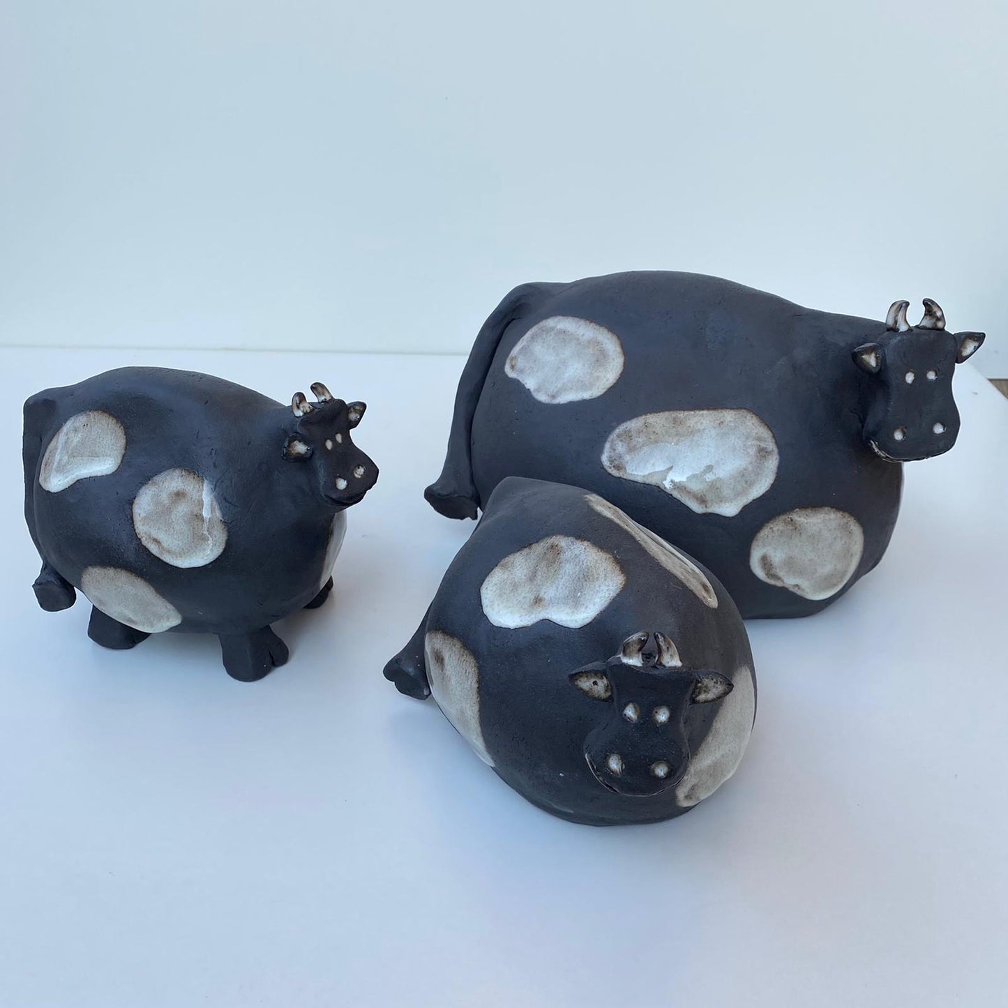 Schwarz-weiß gefleckte Kühe aus Keramik, schwarzer Steinzeugton.